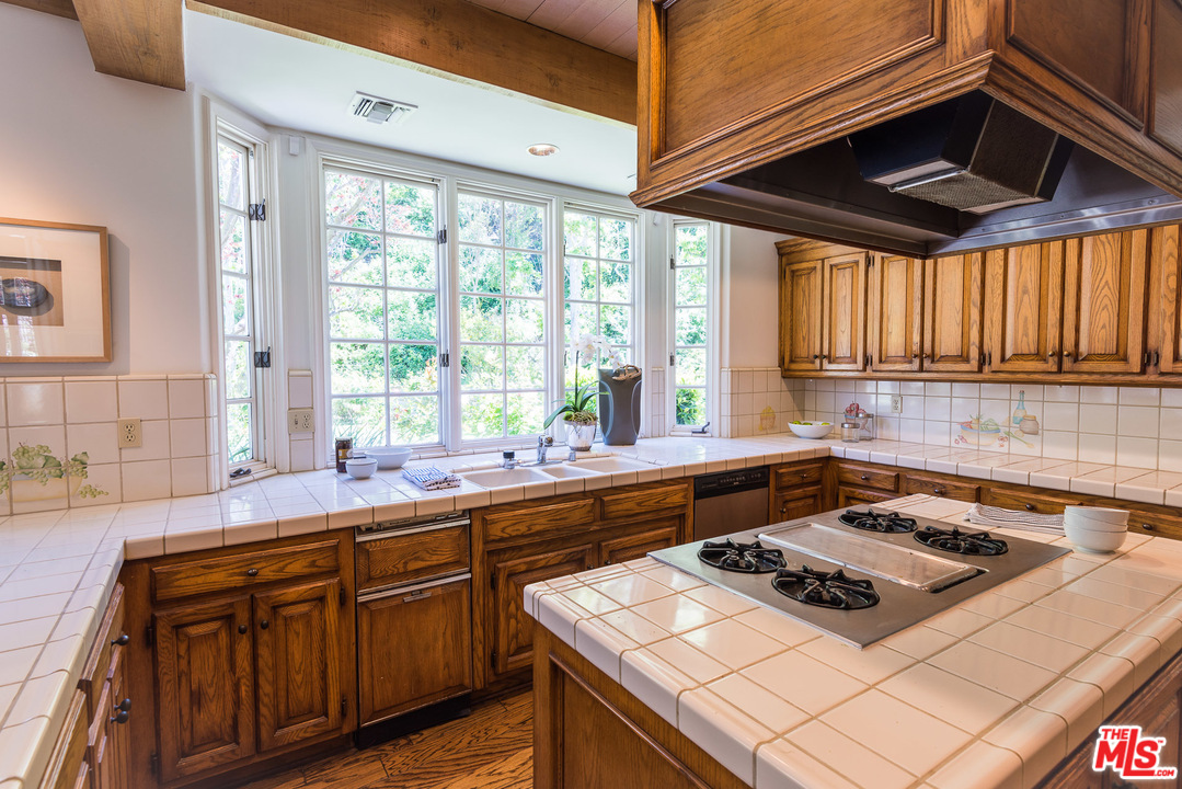 1420 Moraga Drive Los Angeles, CA 90049 - Photo 14 of 38 a kitchen with a stove a sink and a microwave