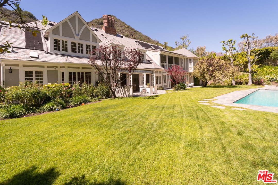 1420 Moraga Drive Los Angeles, CA 90049 - Photo 30 of 38 a view of a big building with a big yard and large trees