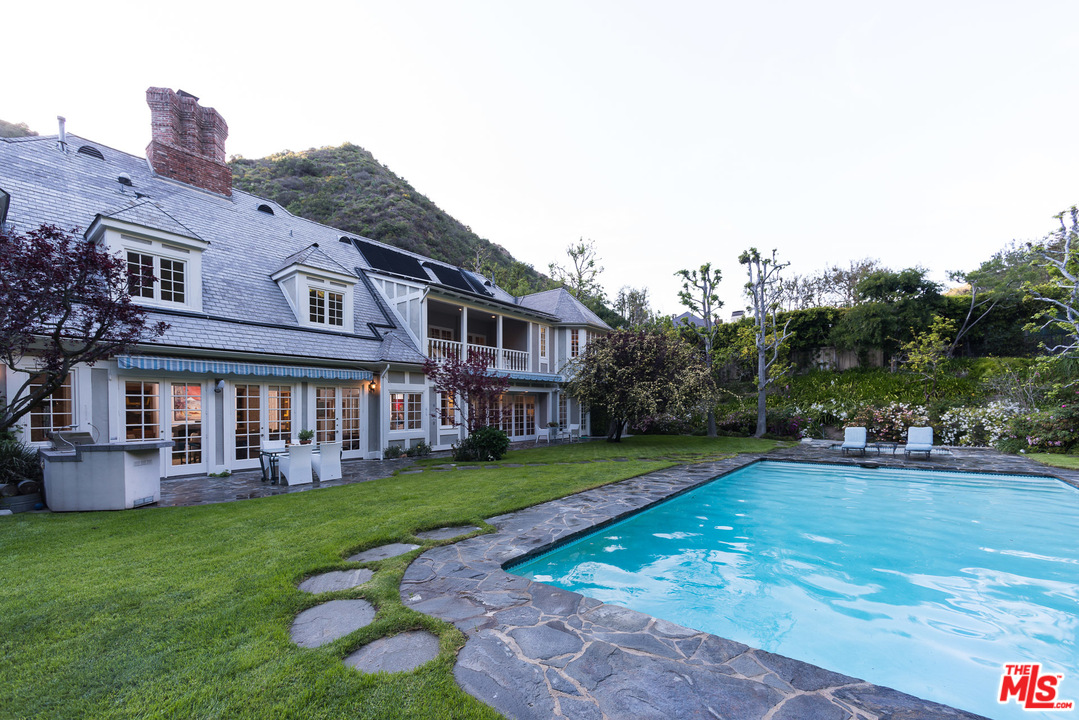 1420 Moraga Drive Los Angeles, CA 90049 - Photo 33 of 38 a view of a house with a yard table and chairs