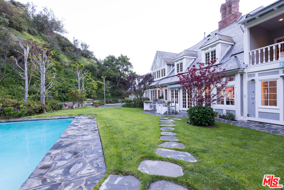 1420 Moraga Drive Los Angeles, CA 90049 - Photo 34 of 38 a front view of a house with garden