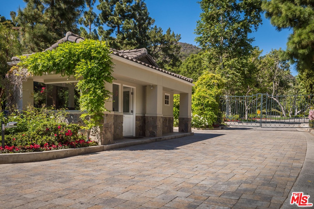 1420 Moraga Drive Los Angeles, CA 90049 - Photo 38 of 38 a front view of a house with a yard and potted plants