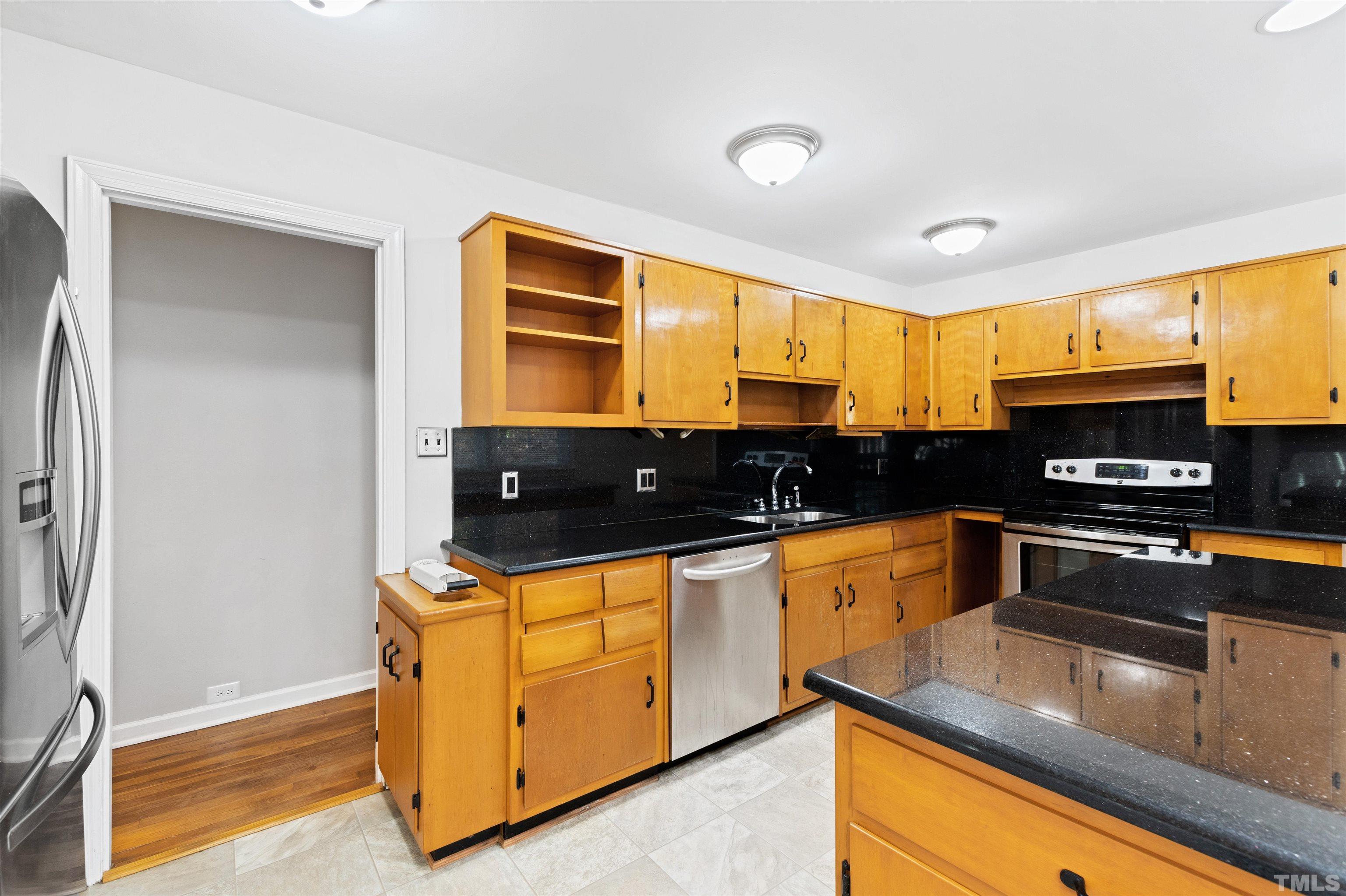 2209 Watkins Street Raleigh, NC 27604 - Photo 12 of 29 a kitchen with stainless steel appliances granite countertop a stove a sink and a refrigerator