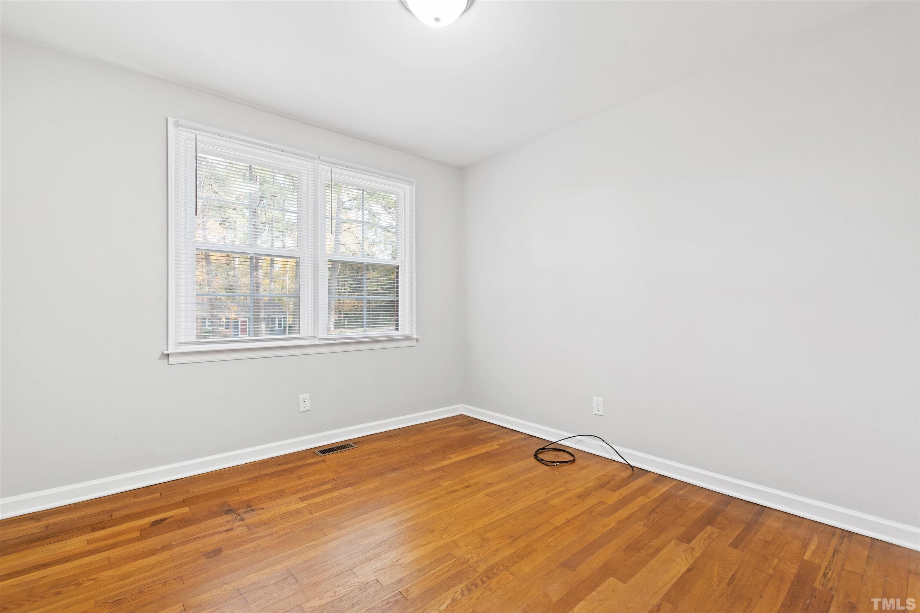 2209 Watkins Street Raleigh, NC 27604 - Photo 14 of 29 a view of an empty room with wooden floor and a window