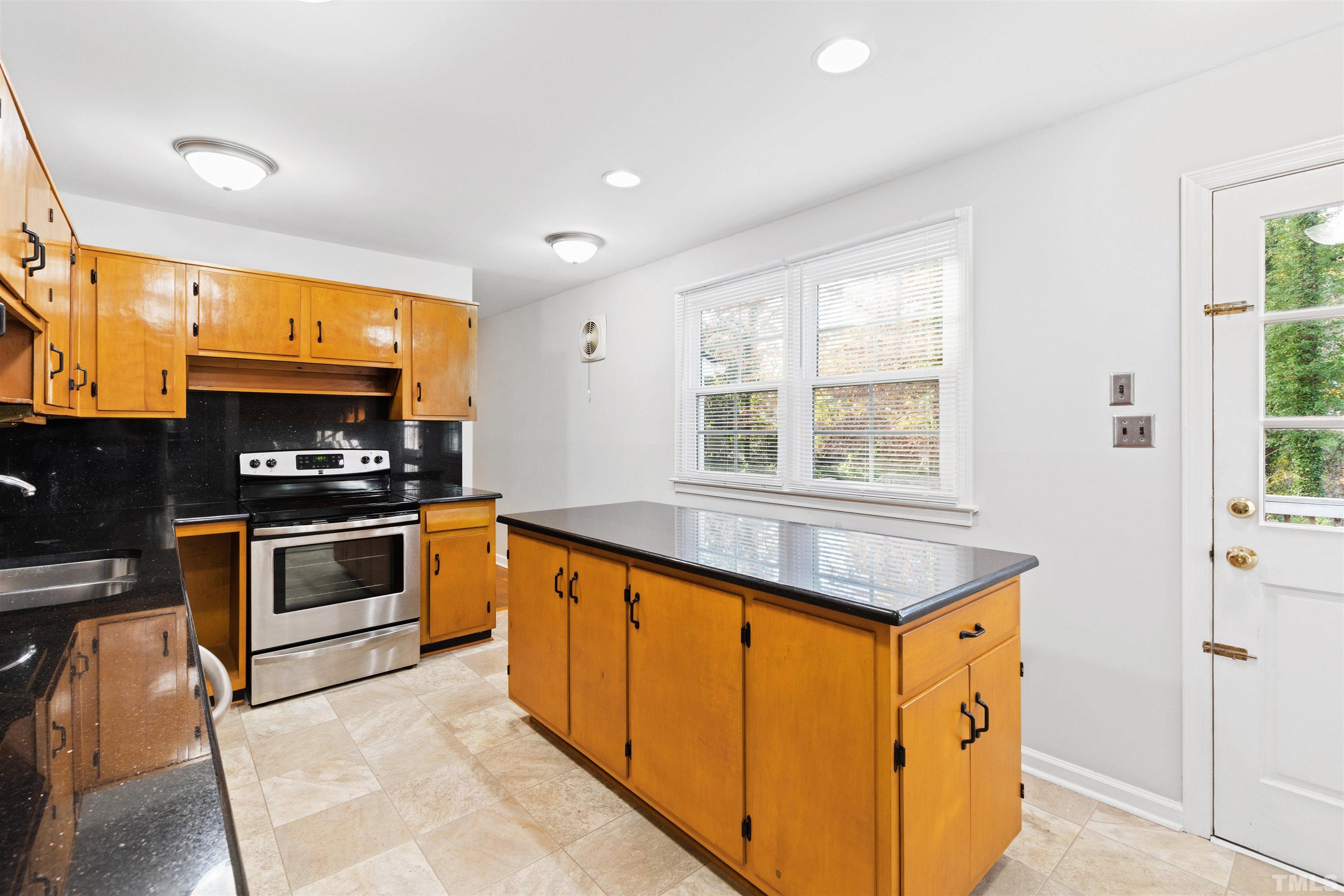 2209 Watkins Street Raleigh, NC 27604 - Photo 10 of 29 a kitchen with stainless steel appliances granite countertop a stove a sink and a refrigerator