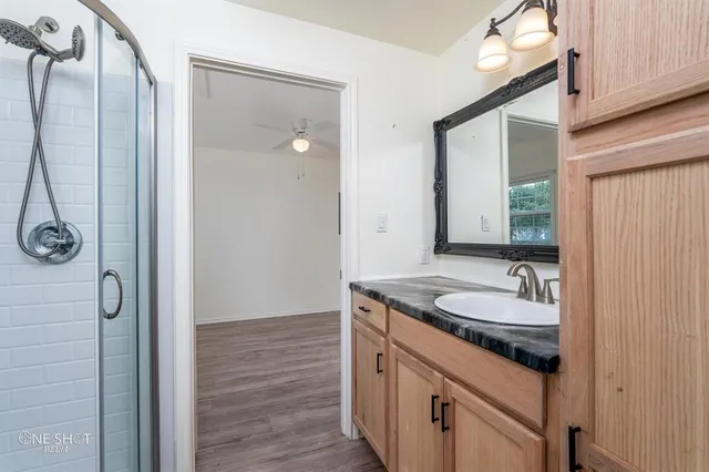 a bathroom with a granite countertop sink and a mirror