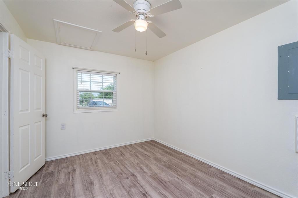 310 10th Street Hawley, TX 79525 - Photo 20 of 29 an empty room with a window and wooden floor