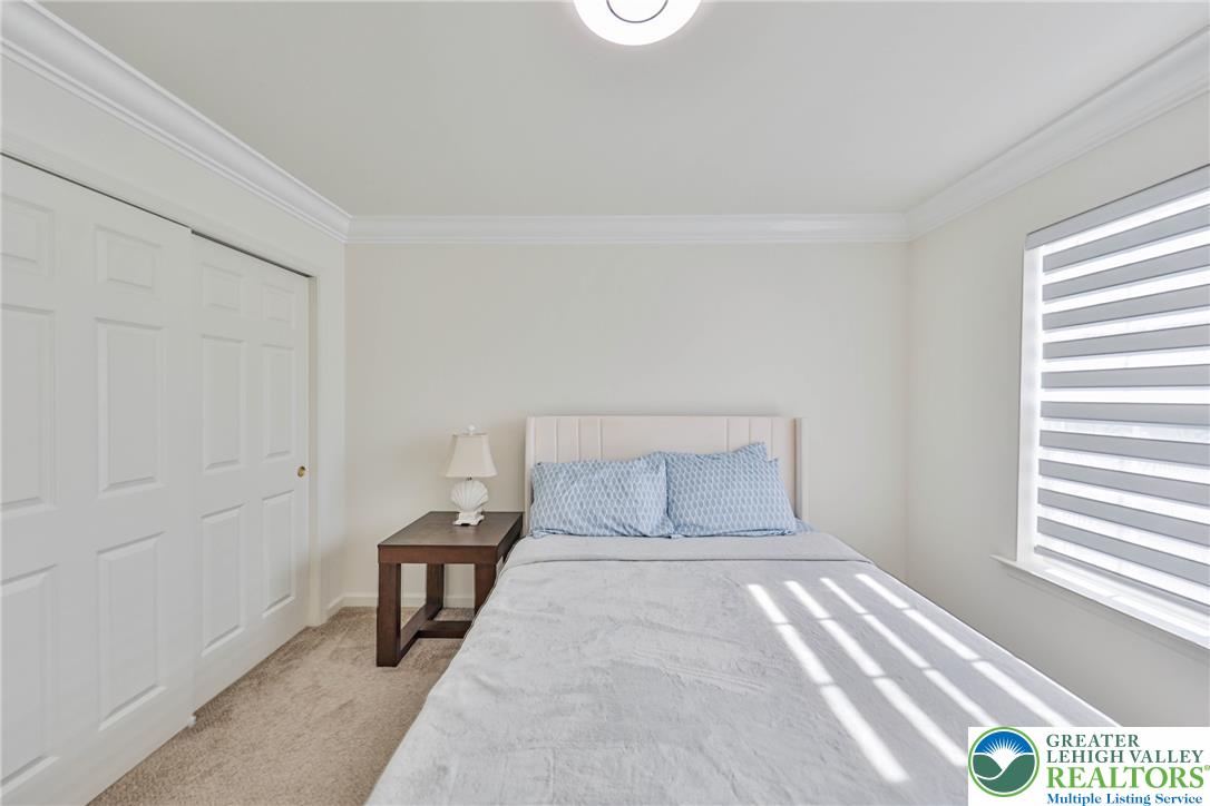 1105 Meco Road Easton, PA 18040 - Photo 80 of 100 Crown molding frames this comfortable bedroom space complete with carpeted flooring and closet storage.
