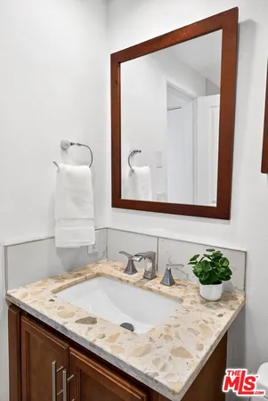 a bathroom with a granite countertop sink and a mirror