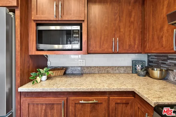 a kitchen with granite countertop a sink a stove and cabinets
