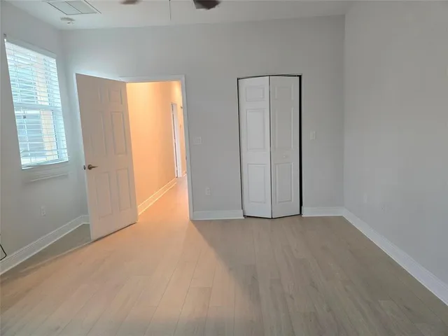an empty room with windows and closet