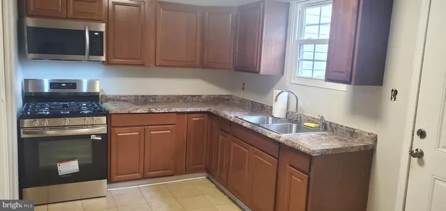 a kitchen with stainless steel appliances granite countertop a sink stove and microwave