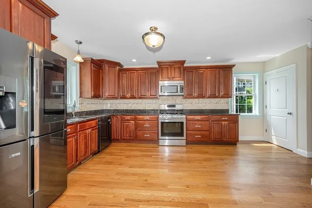 a kitchen with stainless steel appliances granite countertop a stove a sink and a refrigerator