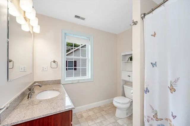 a bathroom with a granite countertop sink toilet and shower