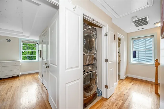 a view of a hallway with wooden floor and a window