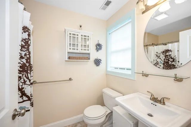 a bathroom with a sink and mirror with toilet