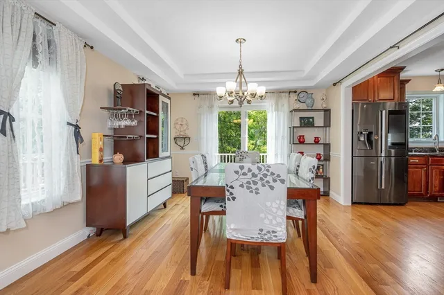 a dining room with furniture a chandelier and wooden floor