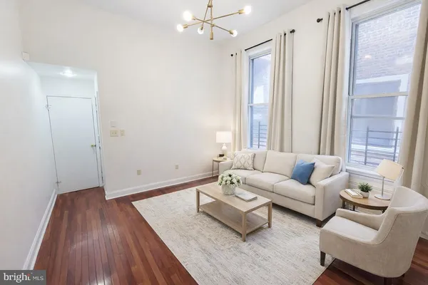 a living room with furniture and wooden floor
