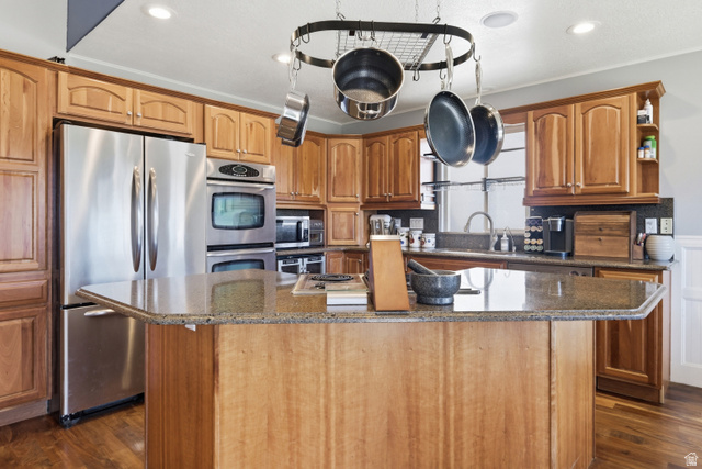860 West 2980th Street South Logan, UT 84321 - Photo 10 of 38 Kitchen featuring a central island with a stone-finish countertop, wood cabinetry, stainless steel appliances including a double oven and refrigerator, and recessed lighting