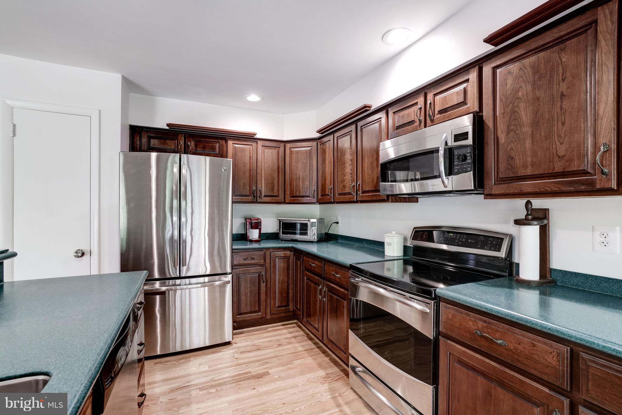 11302 Fairway Drive Reston, VA 20190 - Photo 11 of 30 a kitchen with kitchen island granite countertop stainless steel appliances cabinets a sink and a counter space