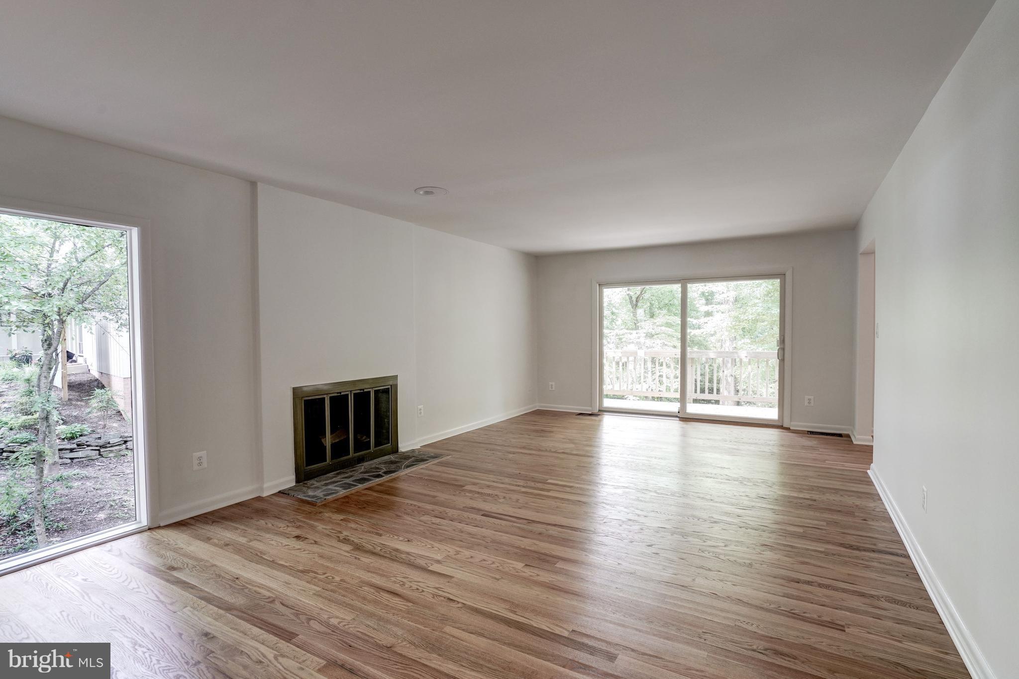 11302 Fairway Drive Reston, VA 20190 - Photo 5 of 30 an empty room with wooden floor fireplace and windows