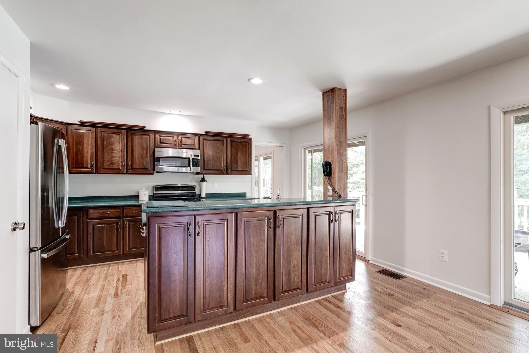 11302 Fairway Drive Reston, VA 20190 - Photo 8 of 30 a kitchen with stainless steel appliances granite countertop a refrigerator and wooden cabinets