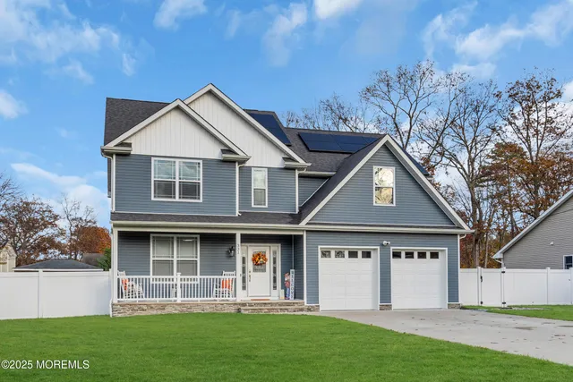 a front view of a house with a garden and trees