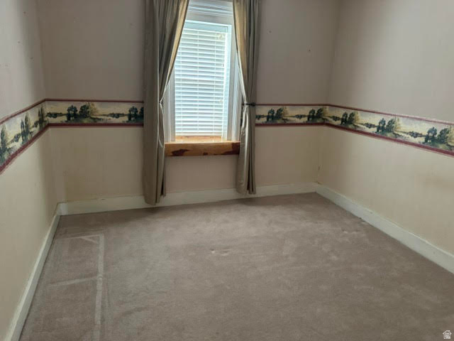 1124 Washam Road Green River, WY 82938 - Photo 23 of 35 Room featuring a window with blinds, a wood window sill, and neutral-toned carpeting