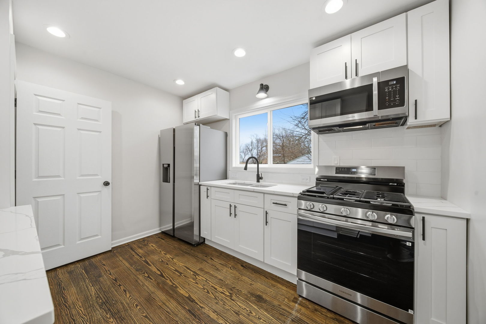 17909 Rose Street Lansing, IL 60438 - Photo 16 of 27 a kitchen with stainless steel appliances a stove a microwave and cabinets