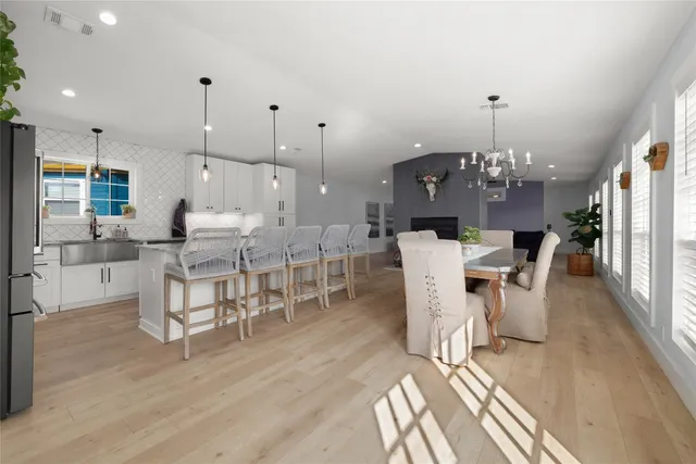 a large white kitchen with lots of counter space a sink a window and stainless steel appliances