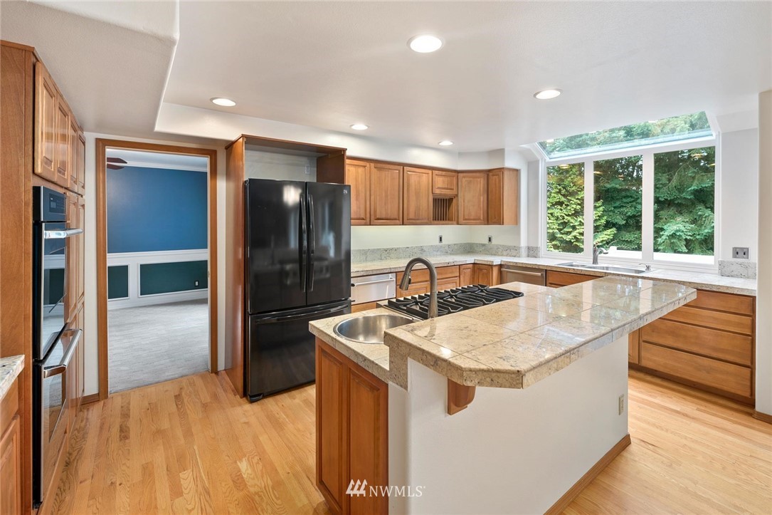 16045 Southeast 149th Street Renton, WA 98059 - Photo 13 of 39 a kitchen with stainless steel appliances granite countertop a sink and a refrigerator