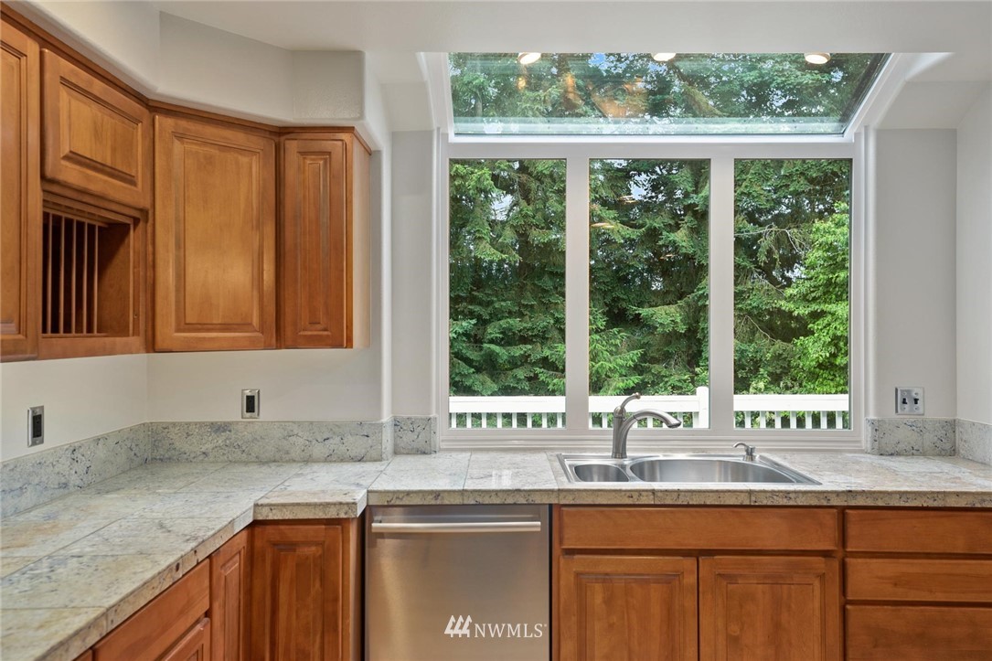 16045 Southeast 149th Street Renton, WA 98059 - Photo 14 of 39 a kitchen with granite countertop a window sink and cabinets