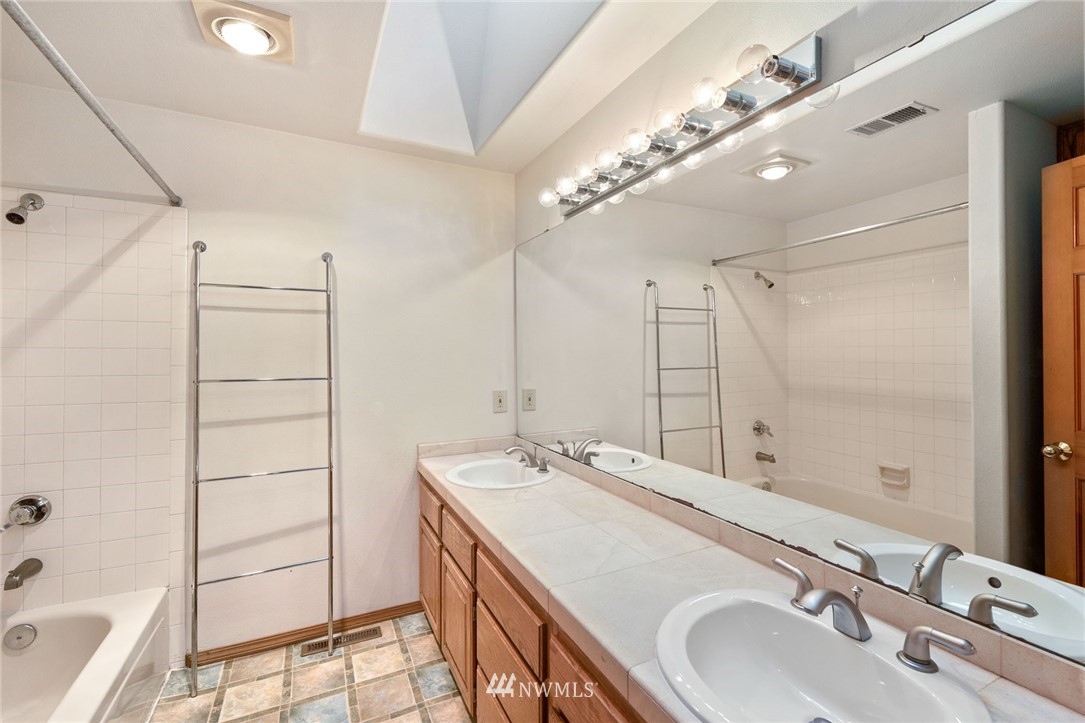 16045 Southeast 149th Street Renton, WA 98059 - Photo 36 of 39 a bathroom with a double vanity sink a mirror and a bathtub