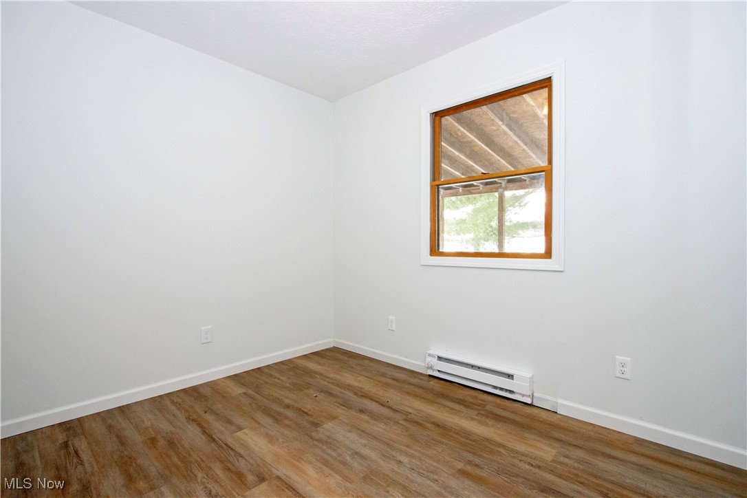 2781 North Firestone Road Wooster, OH 44691 - Photo 16 of 41 Empty room featuring baseboard heating and hardwood / wood-style flooring