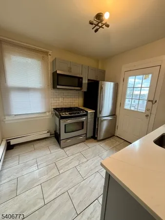 a kitchen with stainless steel appliances a stove a sink and a refrigerator