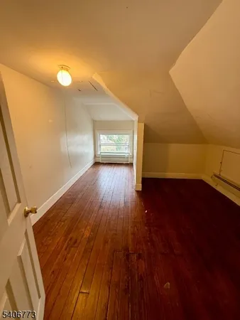 a view of a room with wooden floor and a window