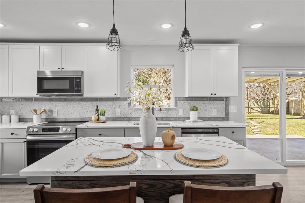 a kitchen with sink stove top oven and cabinets