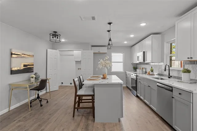 a kitchen with sink cabinets and dining table