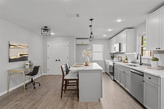a kitchen with a sink a stove a dining table and chairs