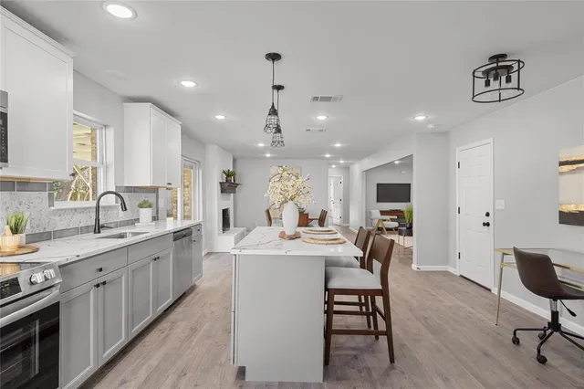 a kitchen with a dining table chairs sink and stove