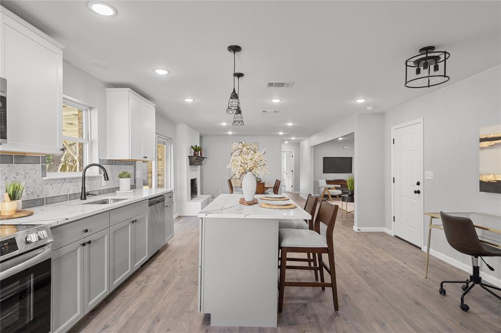 2602 Taylor Street Commerce, TX 75428 - Photo 15 of 37 a kitchen with a dining table chairs sink and stove
