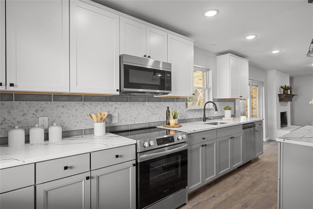 2602 Taylor Street Commerce, TX 75428 - Photo 16 of 37 a kitchen with stainless steel appliances granite countertop a sink dishwasher stove and white cabinets with wooden floor