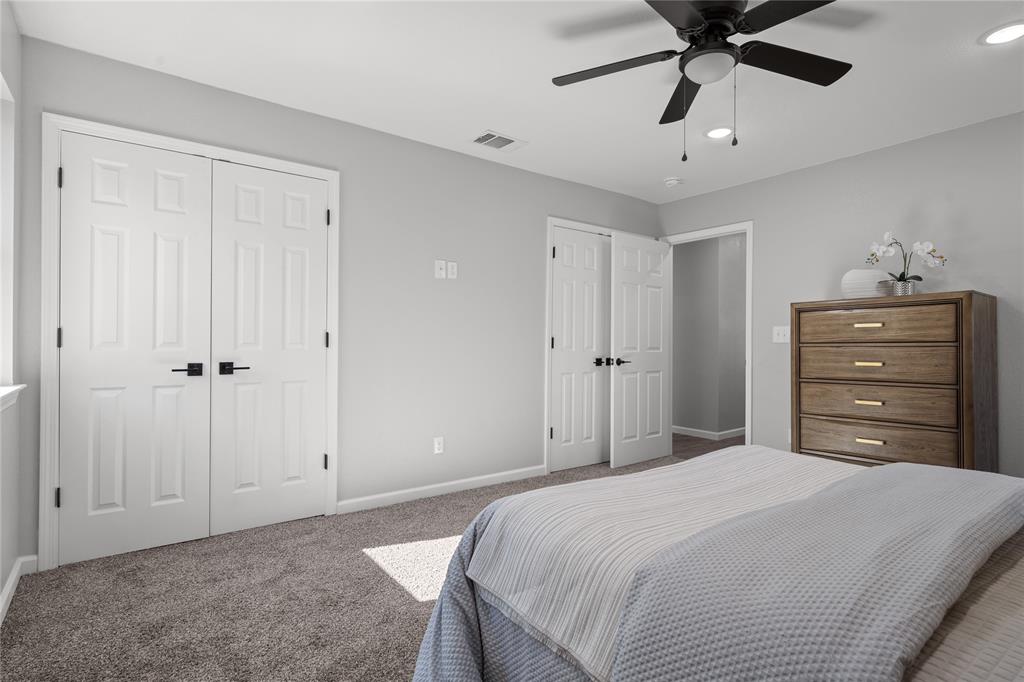 2602 Taylor Street Commerce, TX 75428 - Photo 22 of 37 a bedroom with a bed and a chandelier