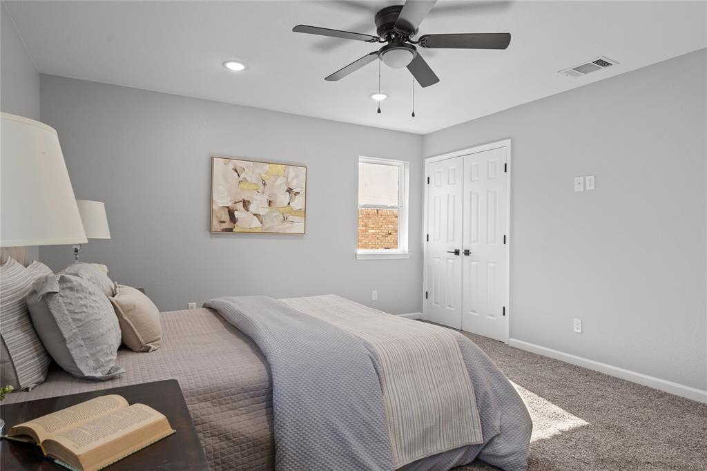 2602 Taylor Street Commerce, TX 75428 - Photo 23 of 37 a bedroom with a large bed and a chandelier