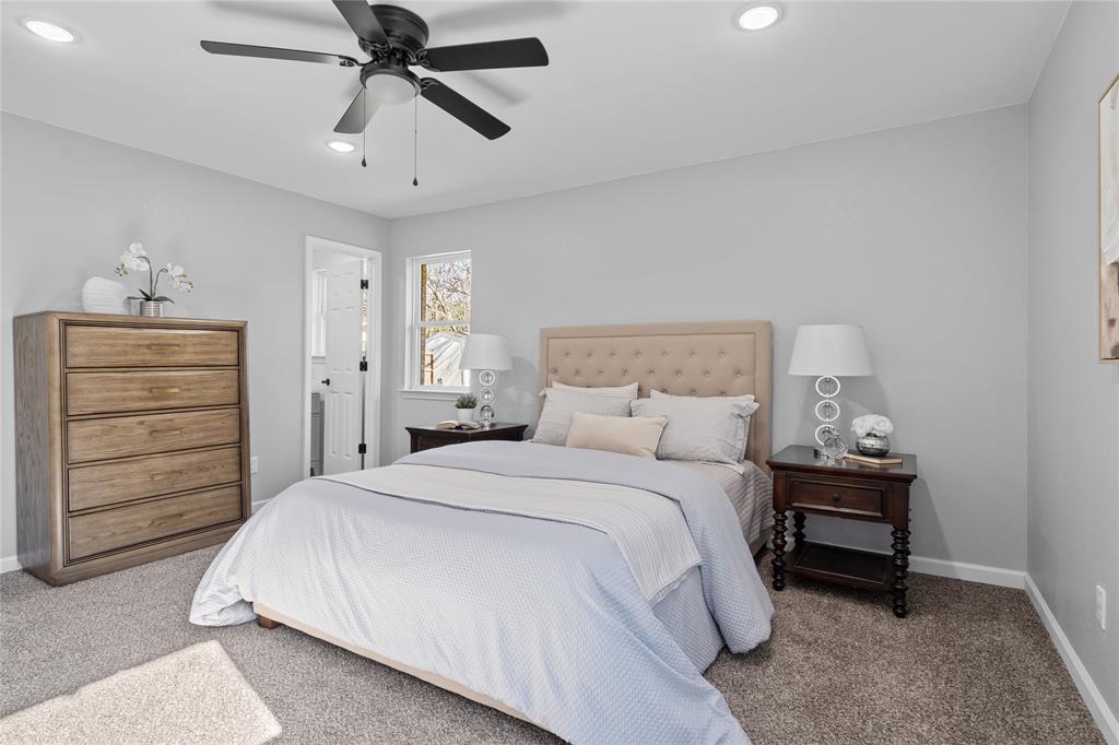 2602 Taylor Street Commerce, TX 75428 - Photo 24 of 37 a bedroom with a bed a dresser and a chandelier