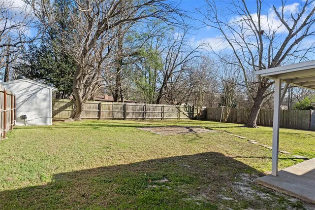 a view of a house with backyard and trees