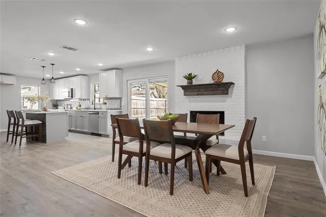a kitchen with a dining table chairs and stainless steel appliances