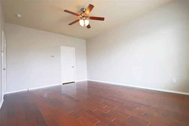 an empty room with a fan and a window