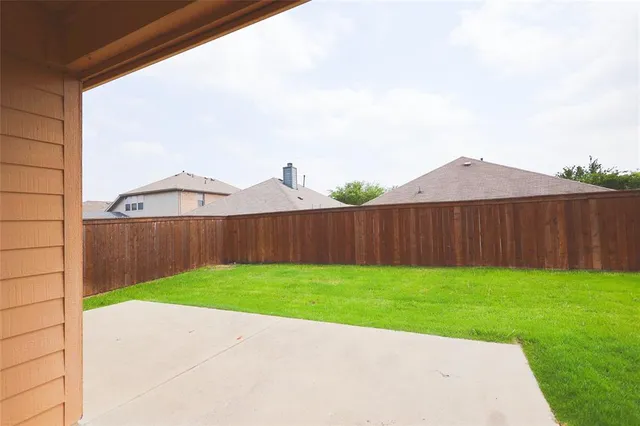 a view of a backyard with wooden fence