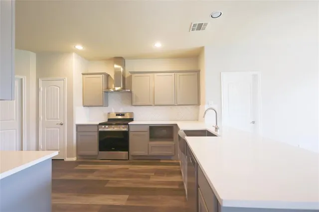 a kitchen with stainless steel appliances granite countertop a sink and a stove