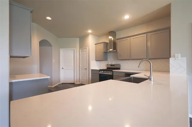 a large white kitchen with sink and refrigerator
